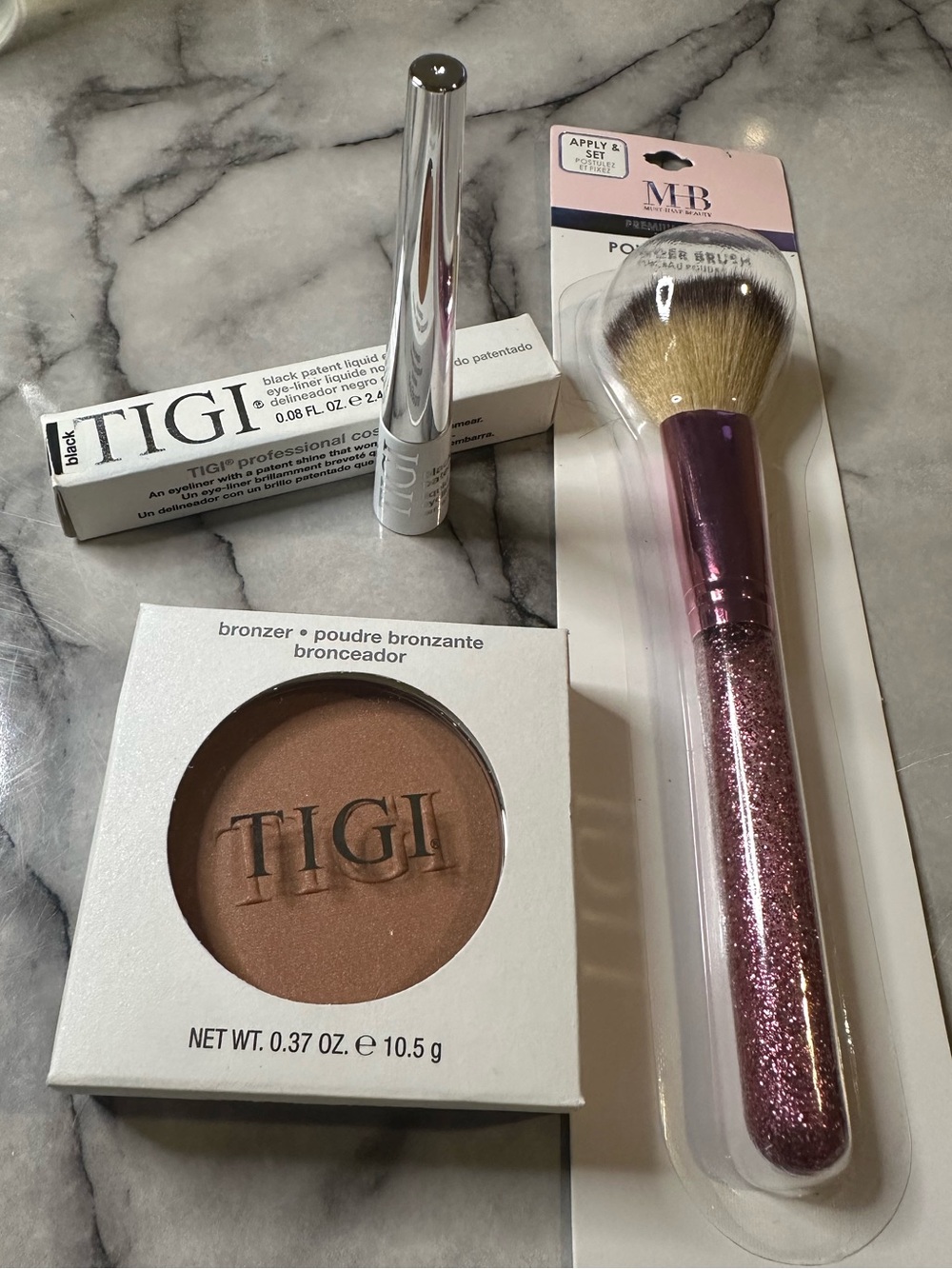 TIGI Bronzer Compact, liquid eyeliner, and blush brush.